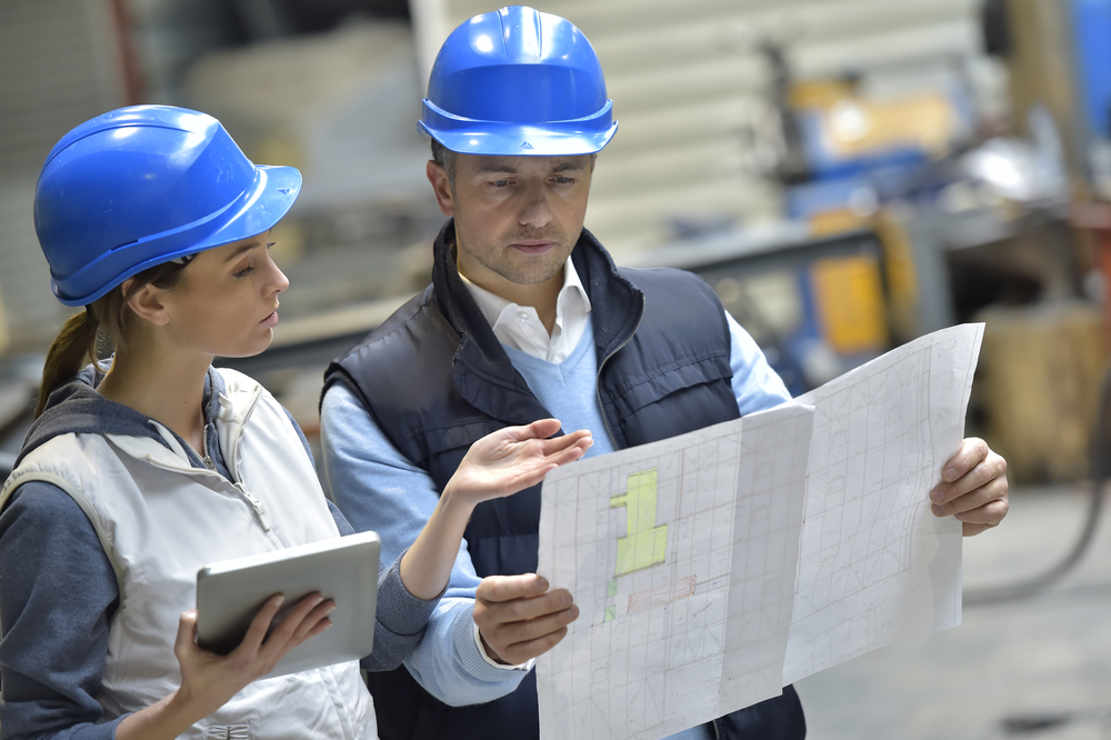 Engineers in mechanical factory reading instructions Engineers in mechanical factory reading instructions